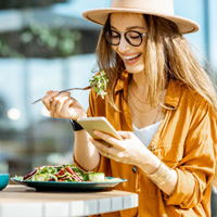 Woman smiling while eating lunch outside
