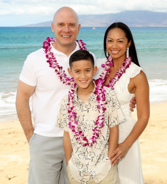 Doctor Skupny and his wife holding their young son's hands and swinging him as they walk