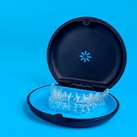 Upper and lower arch Invisalign trays in carrying case with blue background